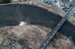 This aerial shot shows the tsunami tidal waves moving upstream. Click image to expand.