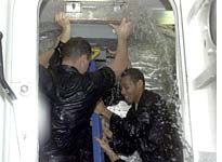 Members of an NBC news crew take part in damage control "wet training" aboard USS Iwo Jima