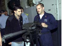 Gunner's mate first-class Mark Napoli demonstrates a Mark 19 Automatic Grenade Launcher to Mark Mazzetti