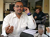 Dipak Patel chats on his cell phone over cappuccino