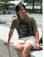 Leung Gwok Hung, "Long Hair," sitting in the courtyard of the Hong Kong legislature building
