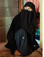 Paridah binti Abas in her husband's home village of Tenggulun, Indonesia, with her eldest son, Zaid. Click image to expand.