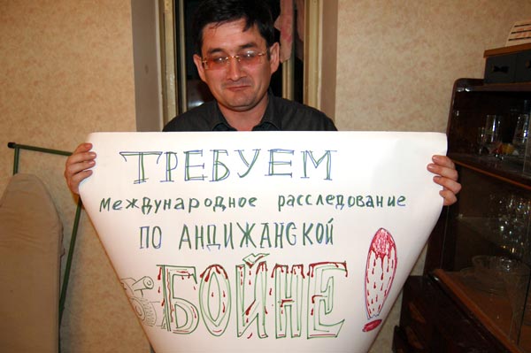 Kudrat Babadjanov shows a poster from an anti-Karimov rally.