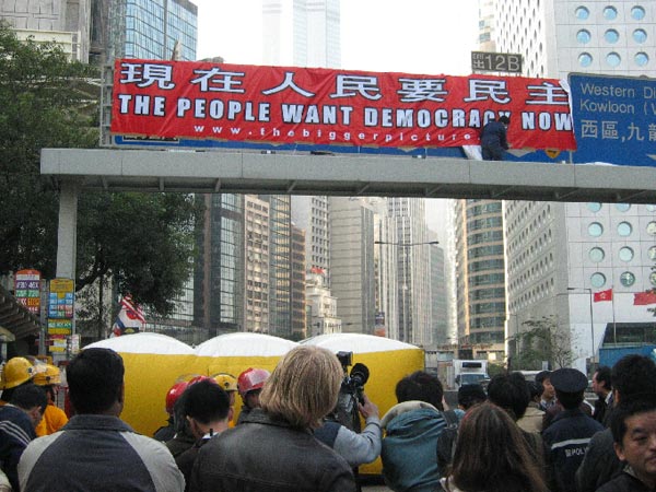 Matt Pearce, aka Spiderman, unfurls his pro-democracy banner.