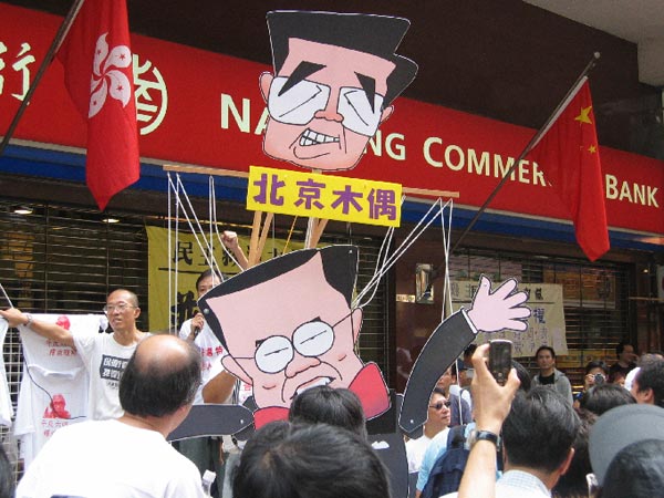 The cardboard puppet portrays Hong Kong Chief Executive Donald Tsang being manipulated by Chinese President Hu Jintao.