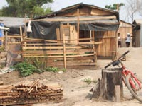 More than 400 families live in the 12-acre encampment; building materials come from the scrap piles of a nearby sawmill. 
Click image to expand.
