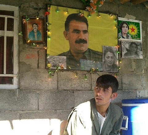 A PKK member under a photo of imprisoned PKK leader Abdullah Ocalan.