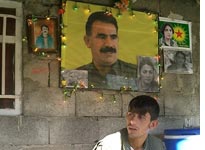 A PKK member under a photo of imprisoned PKK leader Abdullah Ocalan. Click image to expand.