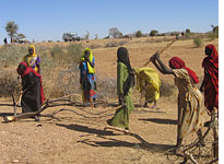 Women gather firewood while A.U. troops watch over them. Click image to expand.