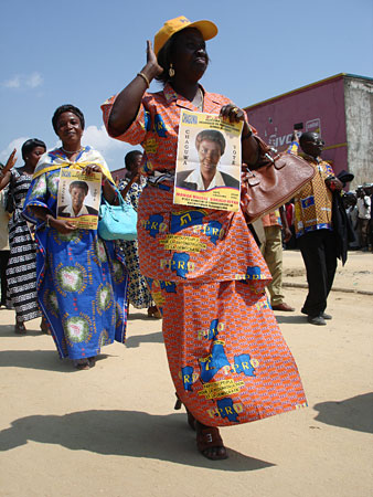 A woman holds a poster for a legislative candidate from the PPRD, the party of President Joseph Kabila.