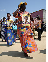A woman holds a poster for a legislative candidate from the PPRD, the party of President Joseph Kabila.Click image to expand.