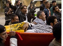 Mourners bury a fighter with aligned with Fatah's armed wing. Click image to expand.