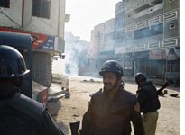 Police amid the billowing tear gas. Click image to expand.