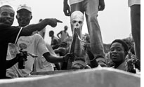 Men brandish a human skull during Decoration Day in Monrovia
Click image to expand.