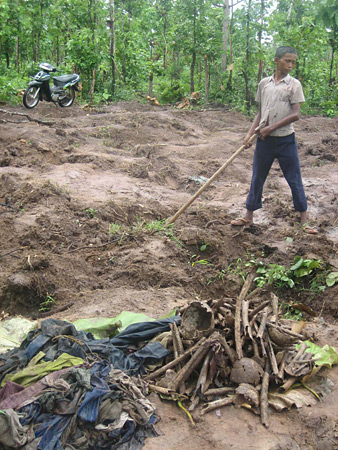 A boy digs through the bones and rags.