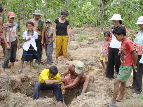 A crowd digs for gold left on the bodies of Khmer Rouge victims.