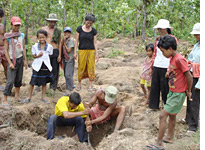 A crowd digs for gold left on the bodies of Khmer Rouge victims 
Click image to expand.