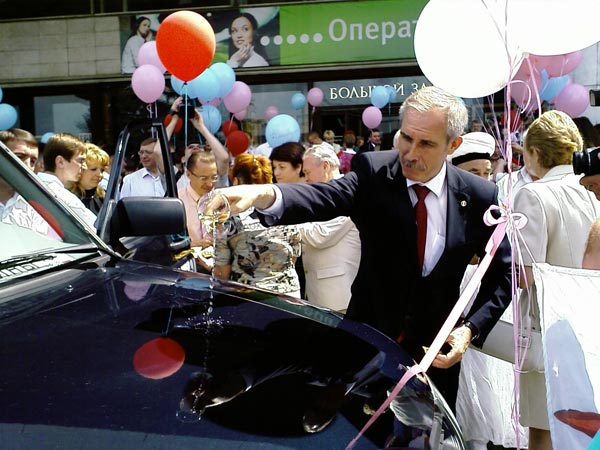 Gov. Sergei Morozov baptizes a UAZ-Patriot, the grand prize for one lucky newborn's family.