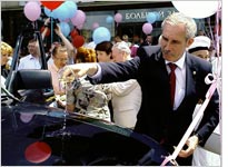 Gov. Sergei Morozov baptizes a UAZ-Patriot, the grand prize for one lucky newborn's family. Click image to expand.