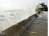 Water crashes over a barrier in Galveston Bay. Click image to expand.