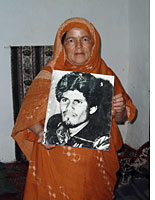 Sahrawi woman holding a picture of El Ouali, the founder of the Polisario Front. Click image to expand.