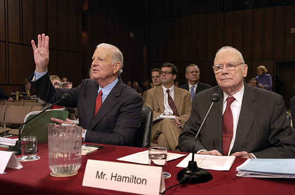 Iraq Study Group co-chair James Baker raises his hand as he testifies before the Senate armed services committee.