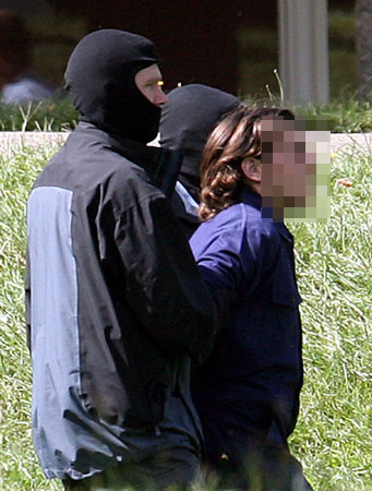 German security leads a suspected terrorist to court.