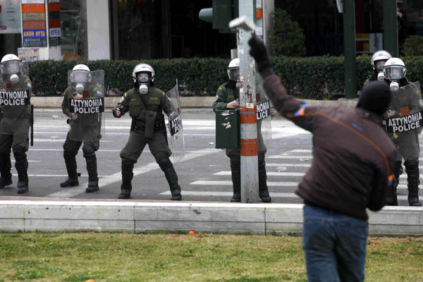 An Athens anarchist throws a stone at riot police.