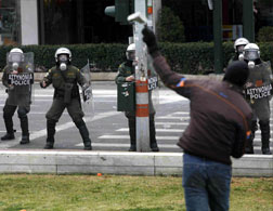 An Athens anarchist throws a stone at riot police. Click image to expand.