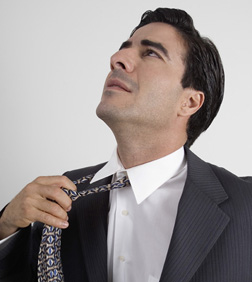 Portrait of a man adjusting his tie.