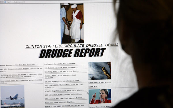 A woman views a page on the Drudge Report featuring a photo of Barack Obama wearing traditional African dress in Kenya.