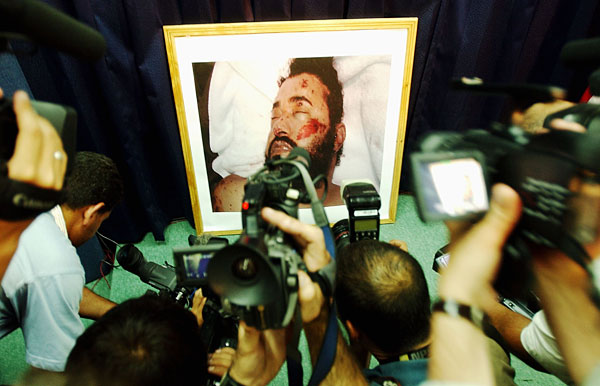 Journalists gather around photo of Zarqawi.