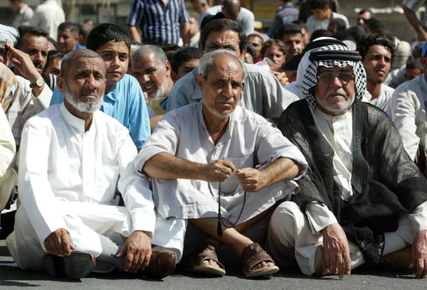 Iraqis sit on the street during a protest against a U.S. air strike.