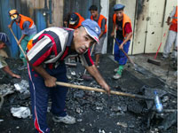 Iraqi workers clear rubble after a car bomb
Click image to expand. 