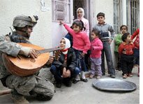 A U.S. soldier plays the oud for some Iraqi children
Click image to expand.