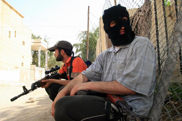 Mahdi Army fighters take cover during clashes in Basra.