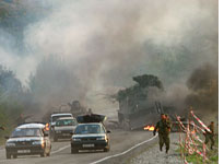 Georgian soldiers run from the scene of a destroyed armored vehicle. Click image to expand.