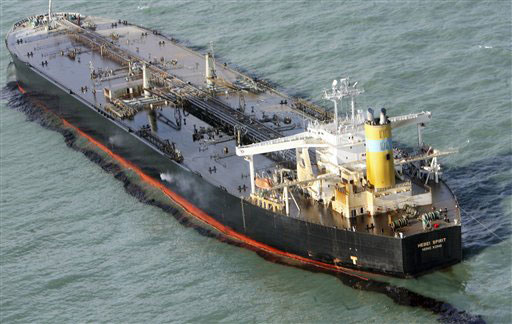 A damaged Hong Kong-registered tanker floats, spilling oil.