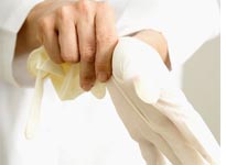 Doctor putting on examination gloves
