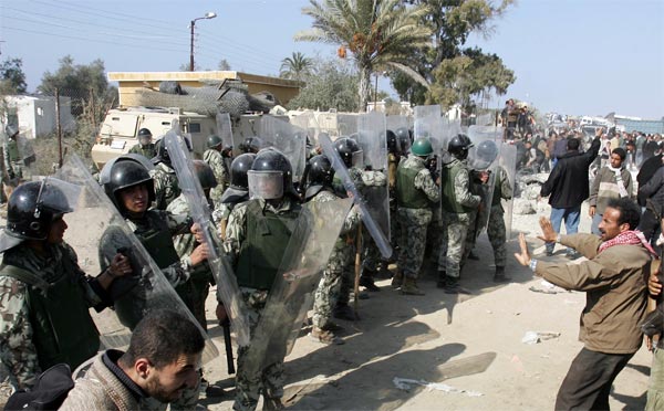 Egyptain riot policemen prevent Palestinian people from crossing the border.