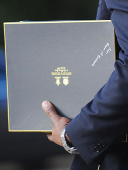 A member of staff of US President Barack Obama carries a gift from Queen Elizabeth II. Click image to expand.