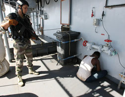 A French soldier guards a suspected Somali pirate. Click image to expand.