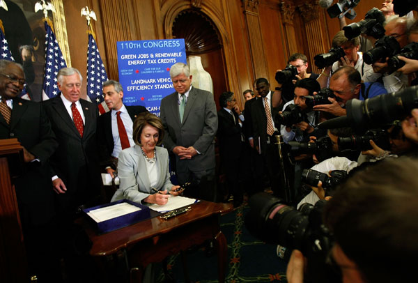 House Speaker Nancy Pelosi signs a financial bailout bill.