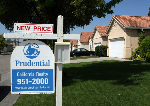 A for sale sign hanging in front of a house.