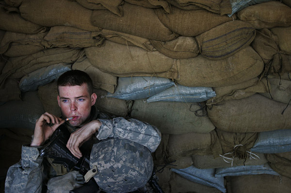 A soldier smokes a cigarette before embarking on a mission in Iraq.