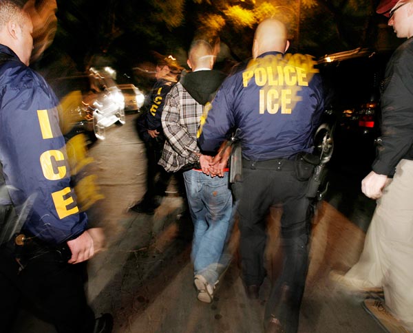 An ICE officer arrests a suspect.