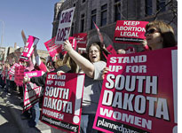 Demonstrators hold up signs as they protest South Dakota's new anti-abortion law outside the Federal Court building in Sioux Falls, S.D., Thursday, March 9, 2006. (AP Photo/Nati Harnik)