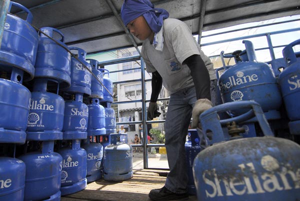 A worker moves canisters of liquefied petroleum gas in the Philippines.