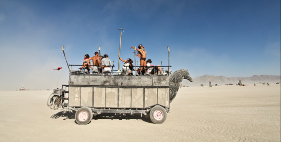 An art car glides through the desert. 