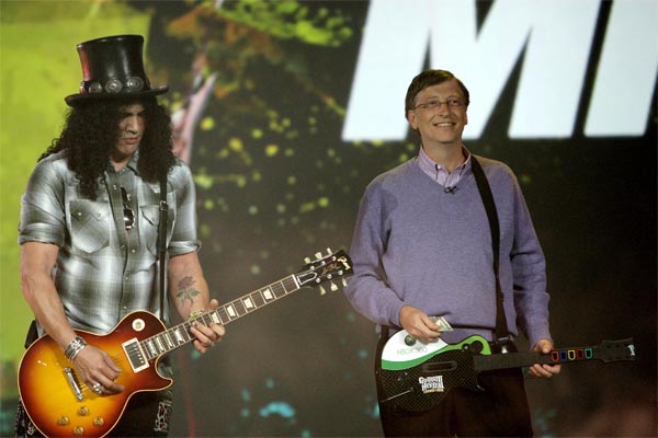 Bill Gates plays Guitar Hero as Slash plays a real guitar.